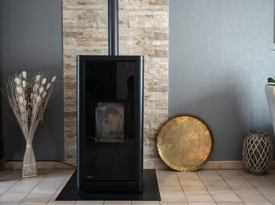 Intérieur moderne avec poêle à pellets noir free-standing, vitrage panoramique frontal, conduit d'évacuation vertical noir mat